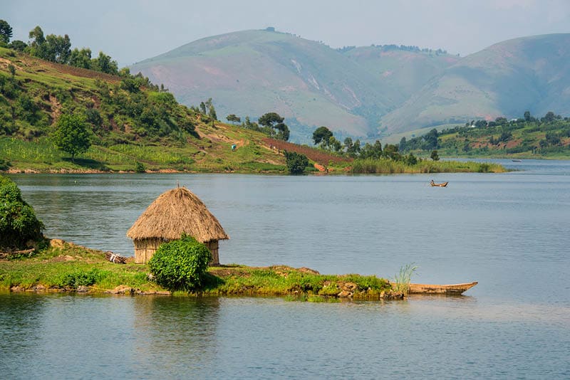 The green shoreline of Lake Kivu between the countries DR Congo and Rwanda in the heart of Africa. Lake Kivu is in the Albertine Rift, the western branch of the East African Rift. Lake Kivu empties into the Ruzizi River, which flows southwards into Lake Tanganyika.