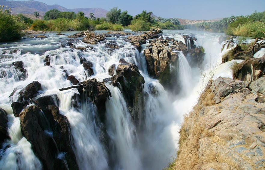 Epupa Falls (also known as Monte Negro Falls in Angola) is a series of large waterfalls created by the Cunene River on the border of Angola and Namibia, in the Kaokoland area of the Kunene Region.