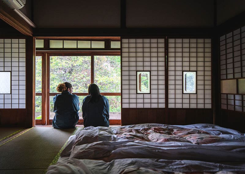 Male and female mixed race guests dressed in yukata enjoying a relaxing stay at a traditional Tokyo ryokan.