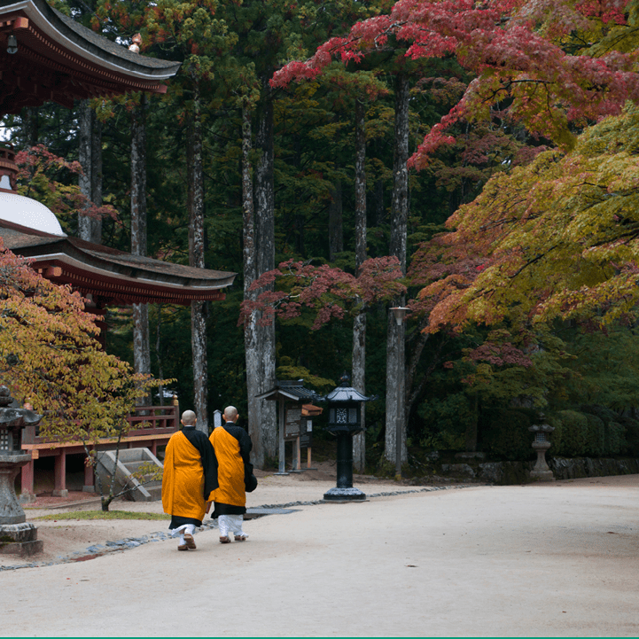 Buddhist monks walking past temple in Koyasan, Mt Koya, Japan during autumn. 