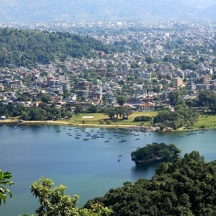 The 4.43 km2-784 ms.high Phewa tal-lake at foot of the Annapurnas range with Pokhara city seen from the way down Ananda Hill-Shanti Stupa-World Peace Pagoda. Kaski distr.-Gandaki zone-Nepal.