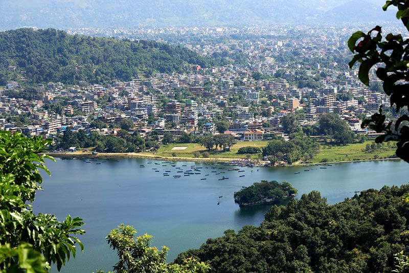 The 4.43 km2-784 ms.high Phewa tal-lake at foot of the Annapurnas range with Pokhara city seen from the way down Ananda Hill-Shanti Stupa-World Peace Pagoda. Kaski distr.-Gandaki zone-Nepal.
