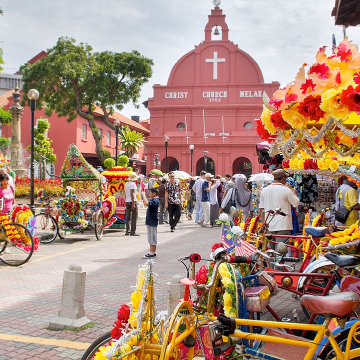 MELAKA, MALAYSIA - JAN 14 : Christ Church Melaka on Jan 14, 2012 in Melaka Malaysia. A popular historic tourist attraction in Melaka Malaysia with flower decorated tricycles for hire.