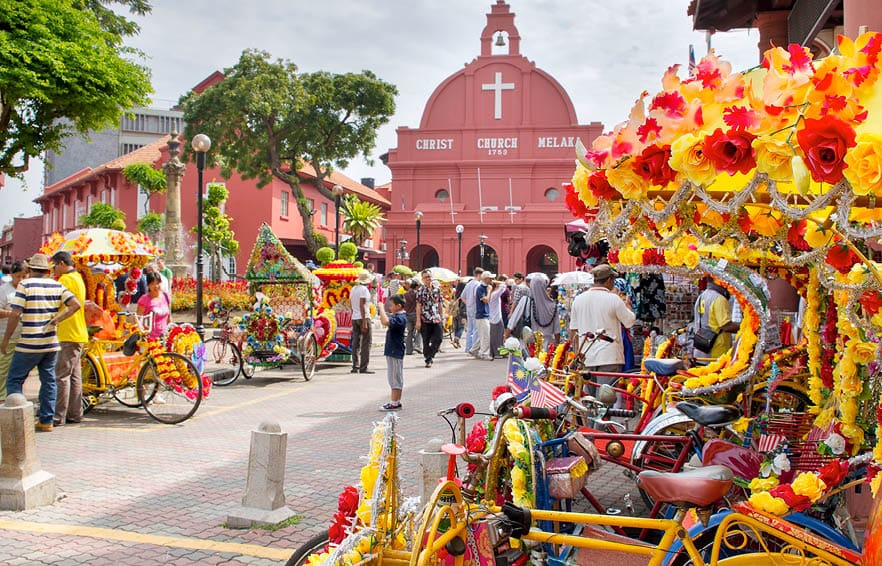 MELAKA, MALAYSIA - JAN 14 : Christ Church Melaka on Jan 14, 2012 in Melaka Malaysia. A popular historic tourist attraction in Melaka Malaysia with flower decorated tricycles for hire.
