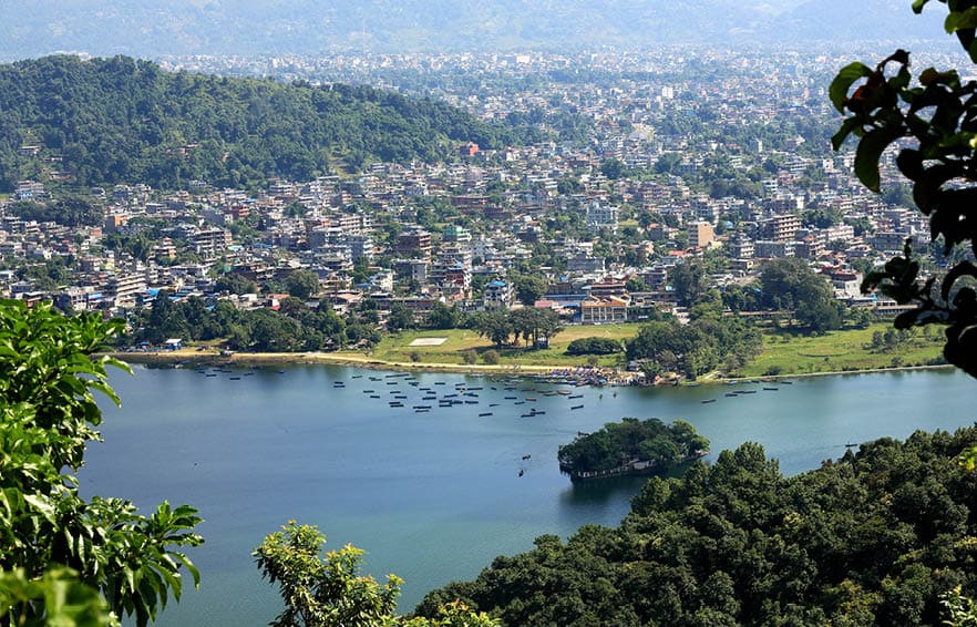 The 4.43 km2-784 ms.high Phewa tal-lake at foot of the Annapurnas range with Pokhara city seen from the way down Ananda Hill-Shanti Stupa-World Peace Pagoda. Kaski distr.-Gandaki zone-Nepal.