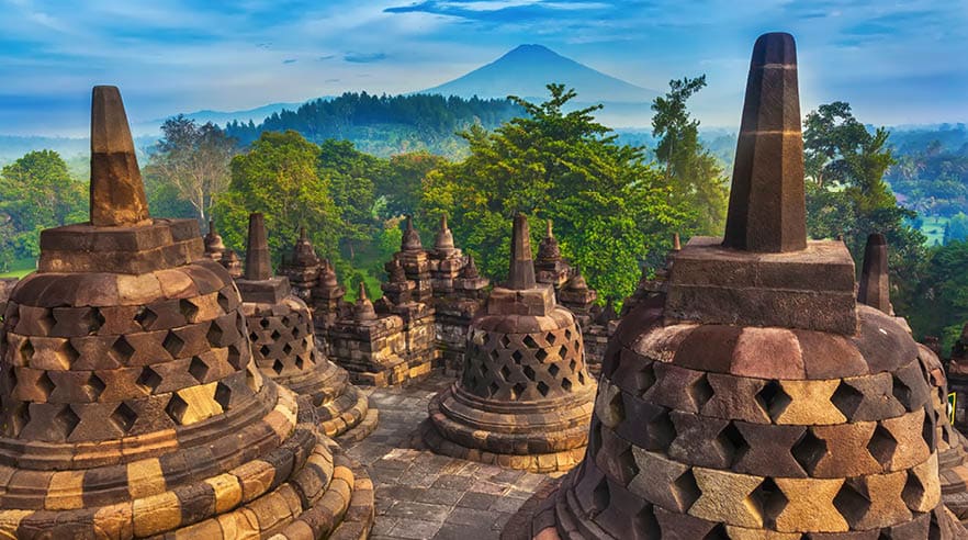 Candi Borobudur in the background of rainforest, morning mist and Sumbing Mountain.