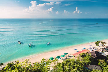 Tropical blue ocean, sandy beach and boats in Indonesia, Bali