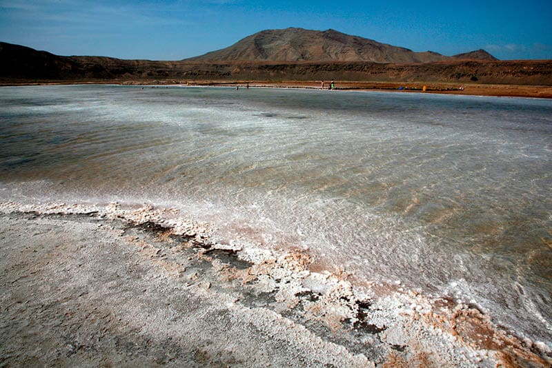 'Salinas' : Salt pans of Pedra de Lume, Inside the crater of a long extinct volcano, Midway up the east coast of Island of Sal, Cape Verde (Cabo Verde), off the West coast of Senegal (West Africa). Cape Verde, an Island Republic in the Atlantic. Formerly an overseas territory of Portugal, gained Independence on July 5th, 1975. 434,812 inhabitants (2000 census). Capital: Praia, Santiago Island.  Sal Surface : 216 km2. 30km long, 12km large. Approx. 14,792 inhabitants. One of the 3 sandy eastern islands of the archipelago. (Ten islands, Nine inhabited). Also the flattest and the driest of all Cape Verde islands. No ground water founded. All water supplies are brought by boat on containers from Praia or elsewhere.  Sal Island has been discovered circa 1460 by Portuguese and named after the Salt Laguna founded in the South and at 'Pedra de Lume', the crater of an extinct volcano. Salt export business exploited from early 19th century attracted many newcomers and brought a relative prosperity till its decline in the first half of the 20th century. By 1985, the salinas ceased all operations. In 1990, there were still 700 residents in Pedra de Lume. Unfortunately, the economy of the town only offers a handful of job opportunities, so the rest had to migrate to other parts of Sal or abroad. The site has now been turned into a resort.
