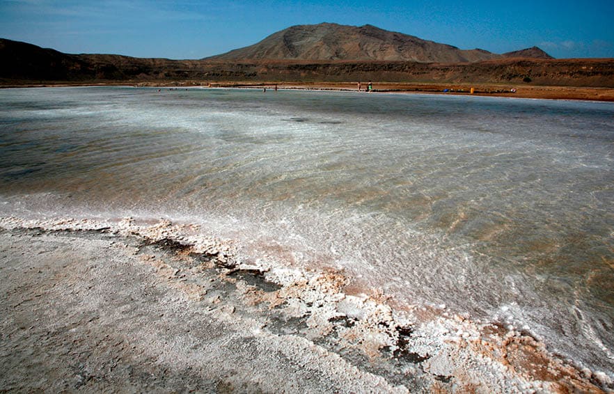 'Salinas' : Salt pans of Pedra de Lume, Inside the crater of a long extinct volcano, Midway up the east coast of Island of Sal, Cape Verde (Cabo Verde), off the West coast of Senegal (West Africa). Cape Verde, an Island Republic in the Atlantic. Formerly an overseas territory of Portugal, gained Independence on July 5th, 1975. 434,812 inhabitants (2000 census). Capital: Praia, Santiago Island.  Sal Surface : 216 km2. 30km long, 12km large. Approx. 14,792 inhabitants. One of the 3 sandy eastern islands of the archipelago. (Ten islands, Nine inhabited). Also the flattest and the driest of all Cape Verde islands. No ground water founded. All water supplies are brought by boat on containers from Praia or elsewhere.  Sal Island has been discovered circa 1460 by Portuguese and named after the Salt Laguna founded in the South and at 'Pedra de Lume', the crater of an extinct volcano. Salt export business exploited from early 19th century attracted many newcomers and brought a relative prosperity till its decline in the first half of the 20th century. By 1985, the salinas ceased all operations. In 1990, there were still 700 residents in Pedra de Lume. Unfortunately, the economy of the town only offers a handful of job opportunities, so the rest had to migrate to other parts of Sal or abroad. The site has now been turned into a resort.
