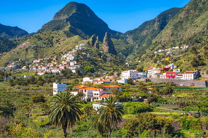 Hermigua and the town's landmark , the characteristic twin rocks Roques de San Pedro. Hermigua is a town and a municipality in the northeastern part of La Gomera in the province of Santa Cruz de Tenerife of the Canary Islands, Spain. It is located 12 km northwest of the island's capital, San Sebasti n de la Gomera. The Garajonay National Park covers the southern part of the municipality.