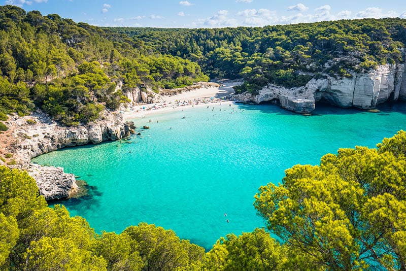 Cala Mitjana beach in Menorca .