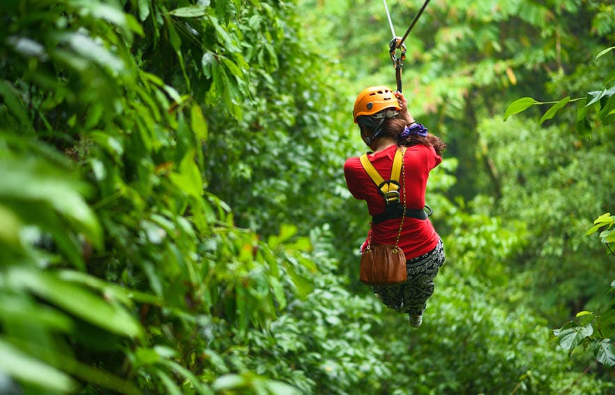 An explorer is moving on cableway in the rainforest