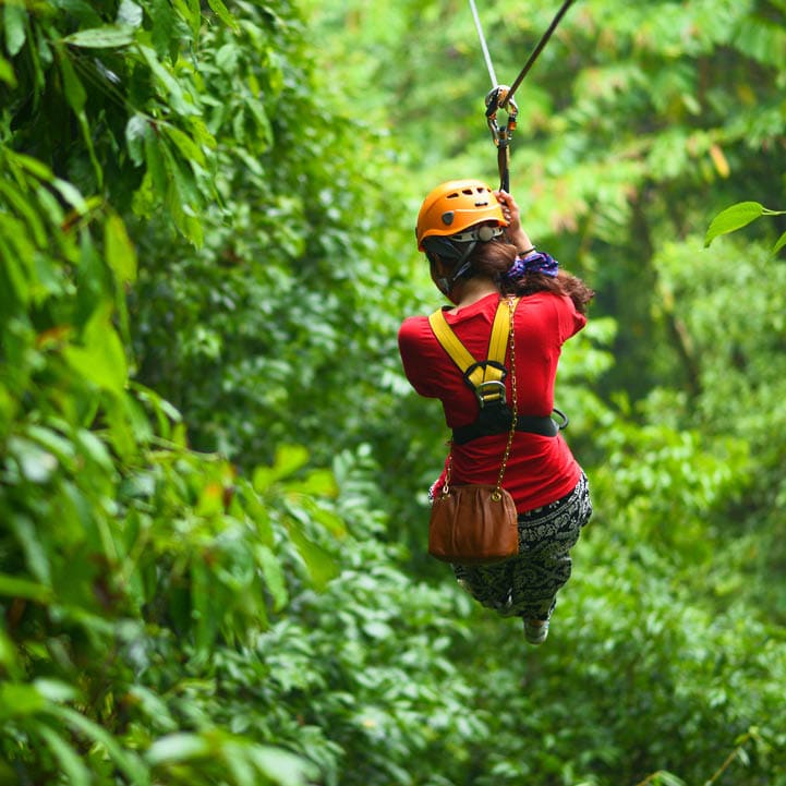 An explorer is moving on cableway in the rainforest