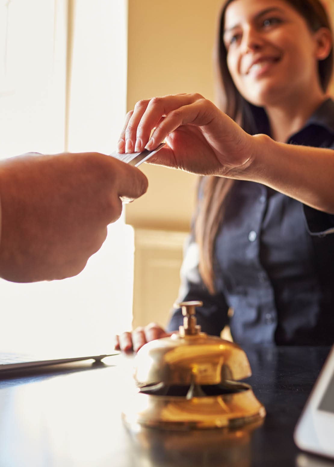 Guest takes room key card at check-in desk of hotel, close up