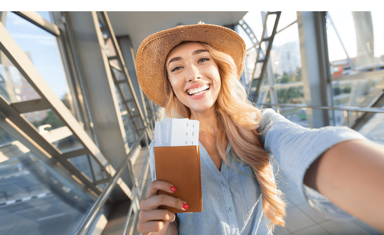 Enjoy traveling. Beautiful woman taking selfie in airport, waiting for boarding