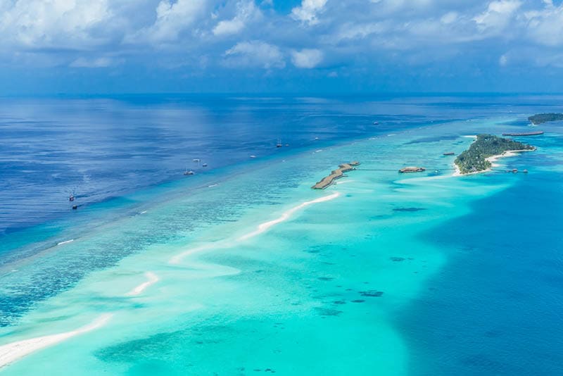 Aerial view on Maldives island, Ari atoll. Tropical islands and atolls in Maldives from aerial view. Summer vacation holiday landscape background.