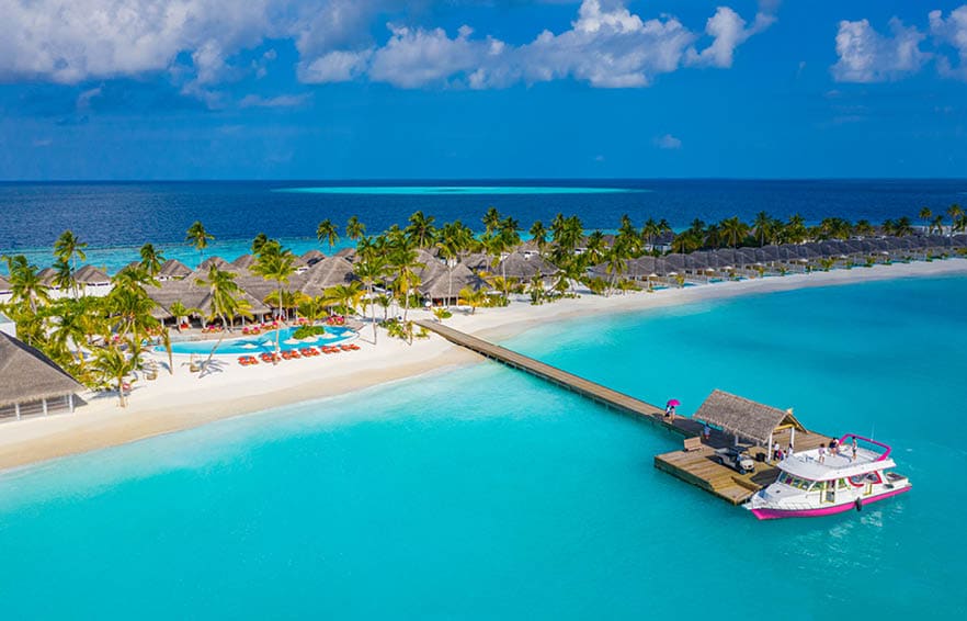 Aerial photo of beautiful Maldives paradise tropical beach. Amazing view, blue turquoise lagoon water, palm trees and white sandy beach. Luxury travel vacation destination. Sunny aerial landscape