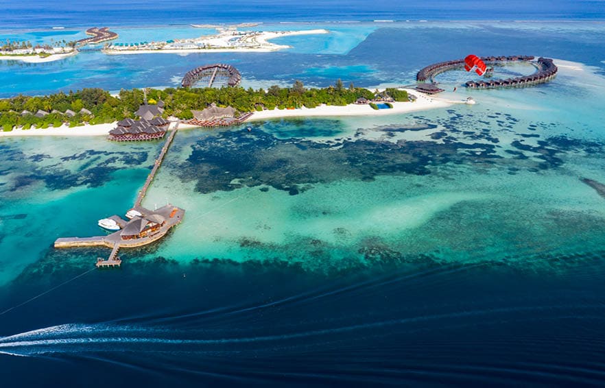 Aerial view, paraglider flies along an atoll of Maldives, South Male Atoll Maldives