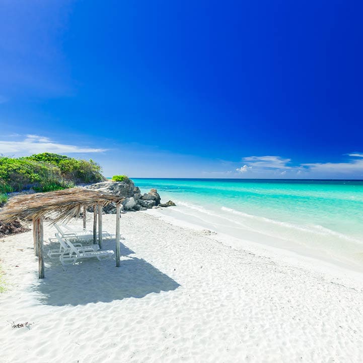 stunning, amazing inviting view of tropical white sand beach and tranquil turquoise ocean on dark deep, blue sky background at Cayo Coco Cuban island, sunny summer beautiful day