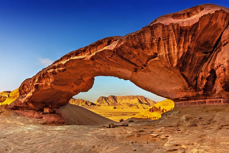 View through a rock arch in the desert of Wadi Rum, Jordan, Middle East