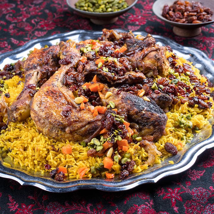 Traditional fried Arabic chicken majboos with chicken leg and jeweled rice served as close-up in a rustic oriental tray 