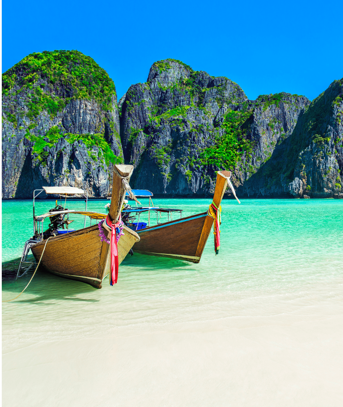 Famous scenic Maya Bay beach at Ko Phi Phi Leh Island with two traditional longtail taxi boats mooring and steep limestone hills in background, Thailand, part of Krabi Province, Andaman Sea