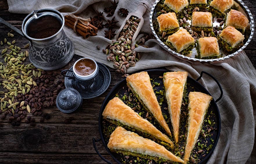 Baklava with pistachio in the plates. Carrot piece and dry baklava. Desserts with sugar syrup. 