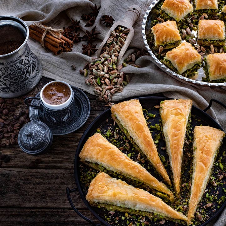 Baklava with pistachio in the plates. Carrot piece and dry baklava. Desserts with sugar syrup. 