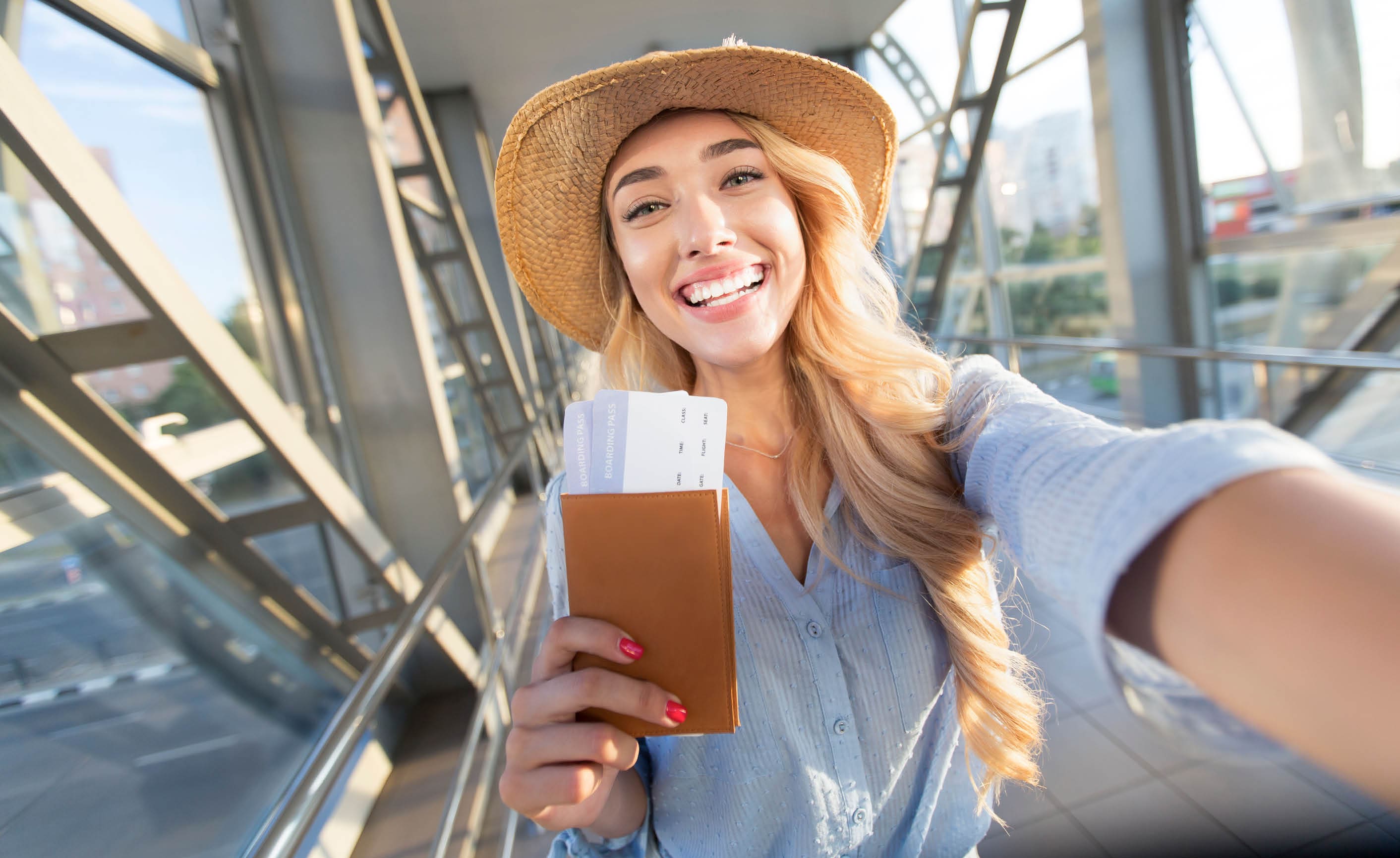 Enjoy traveling. Beautiful woman taking selfie in airport, waiting for boarding