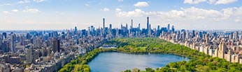 Aerial view of the Central park in New York with golf fields and tall skyscrapers surrounding the park.