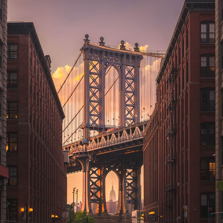 Manhattan bridge seen from a brick buildings in Brooklyn street in perspective, New York, USA. Shot in the evening