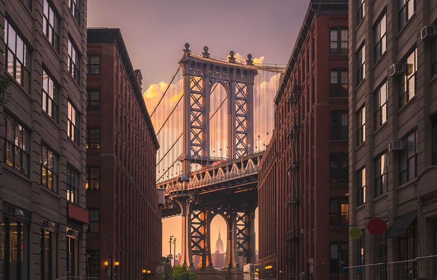 Manhattan bridge seen from a brick buildings in Brooklyn street in perspective, New York, USA. Shot in the evening